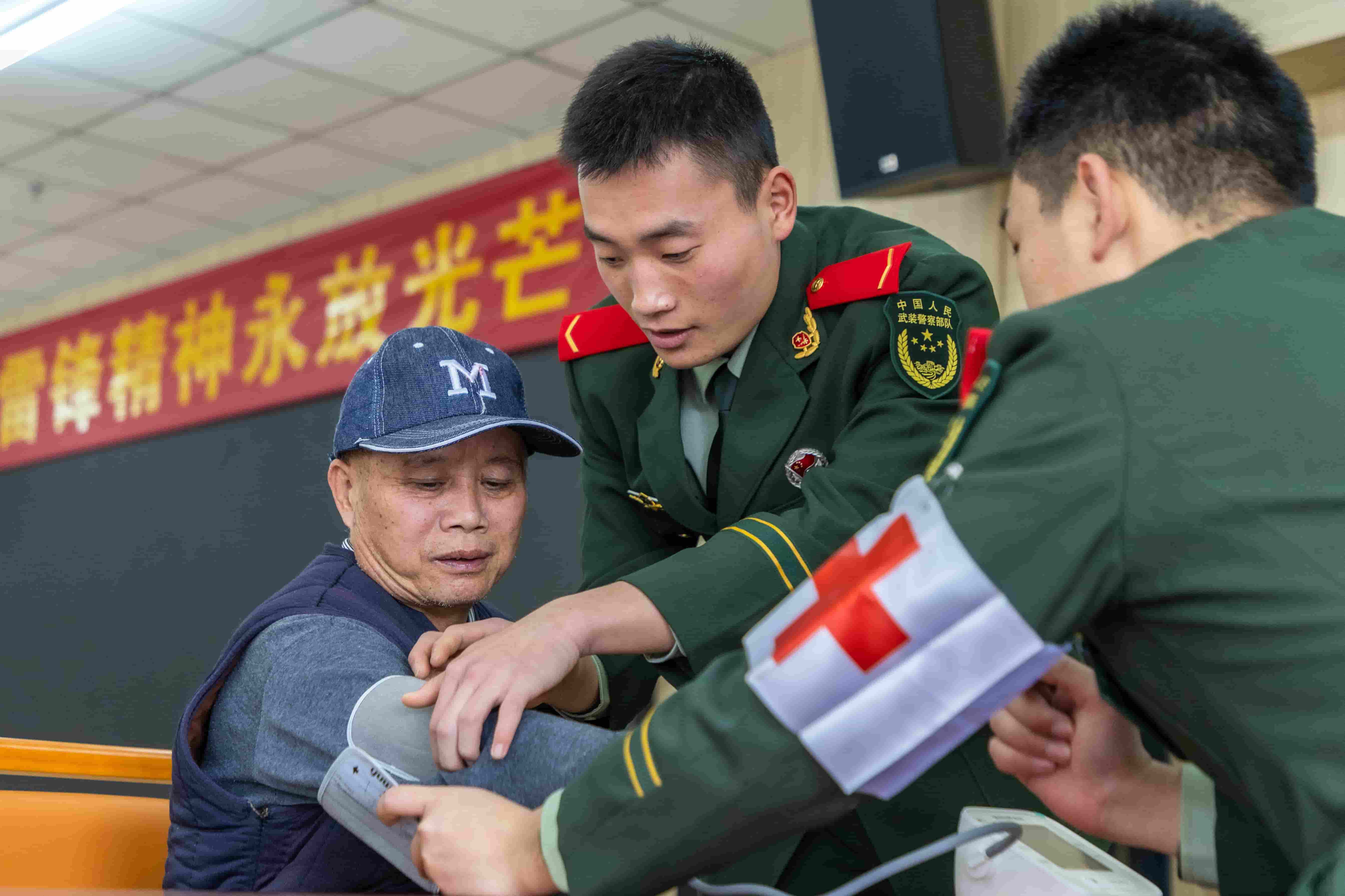 3月1日,武警广西总队桂林支队官兵在龙胜各族自治县福利院利用血压计为老人测量血压。 屠凌烽 摄.jpg